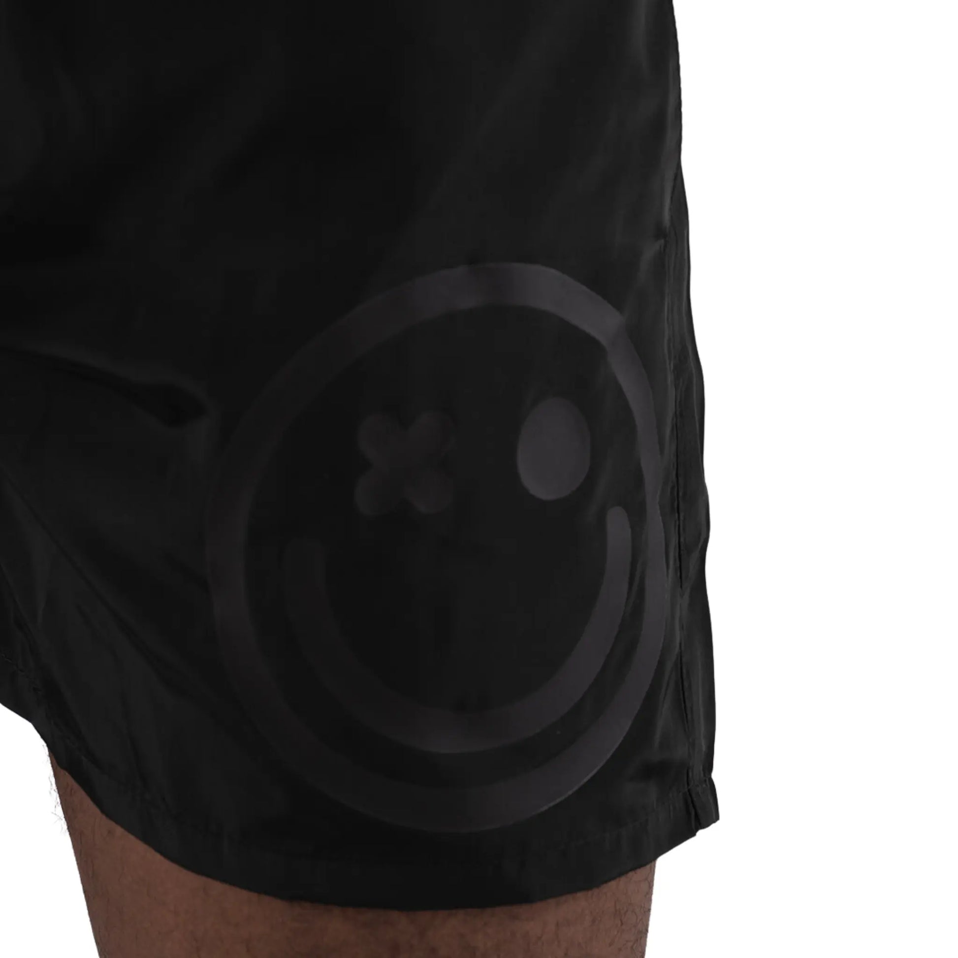 L’Homme Moderne Smiley Swimwear Black worn on black man close up view on smiley logo