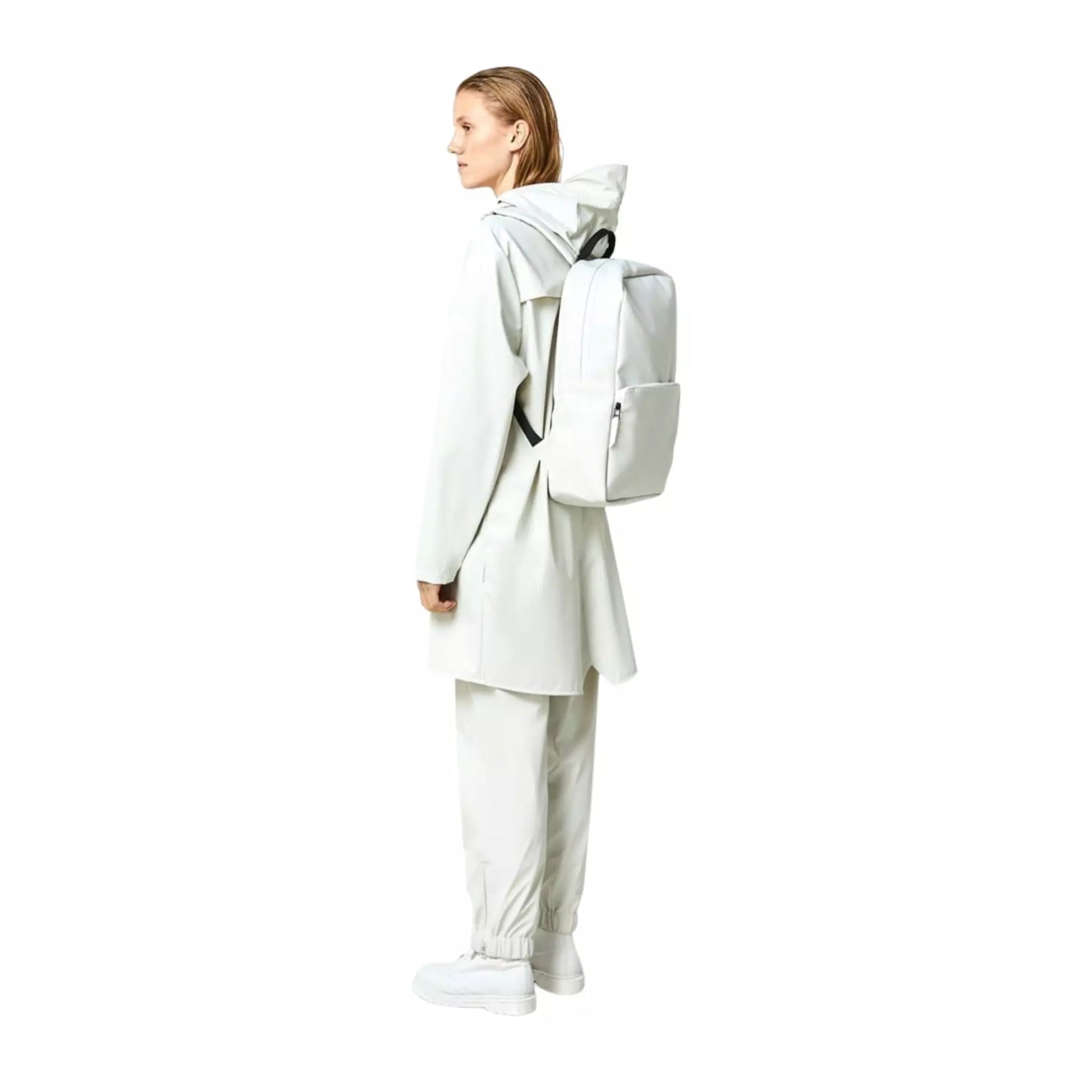 Rains waterproof backpack field bag off white worn on the back of a woman