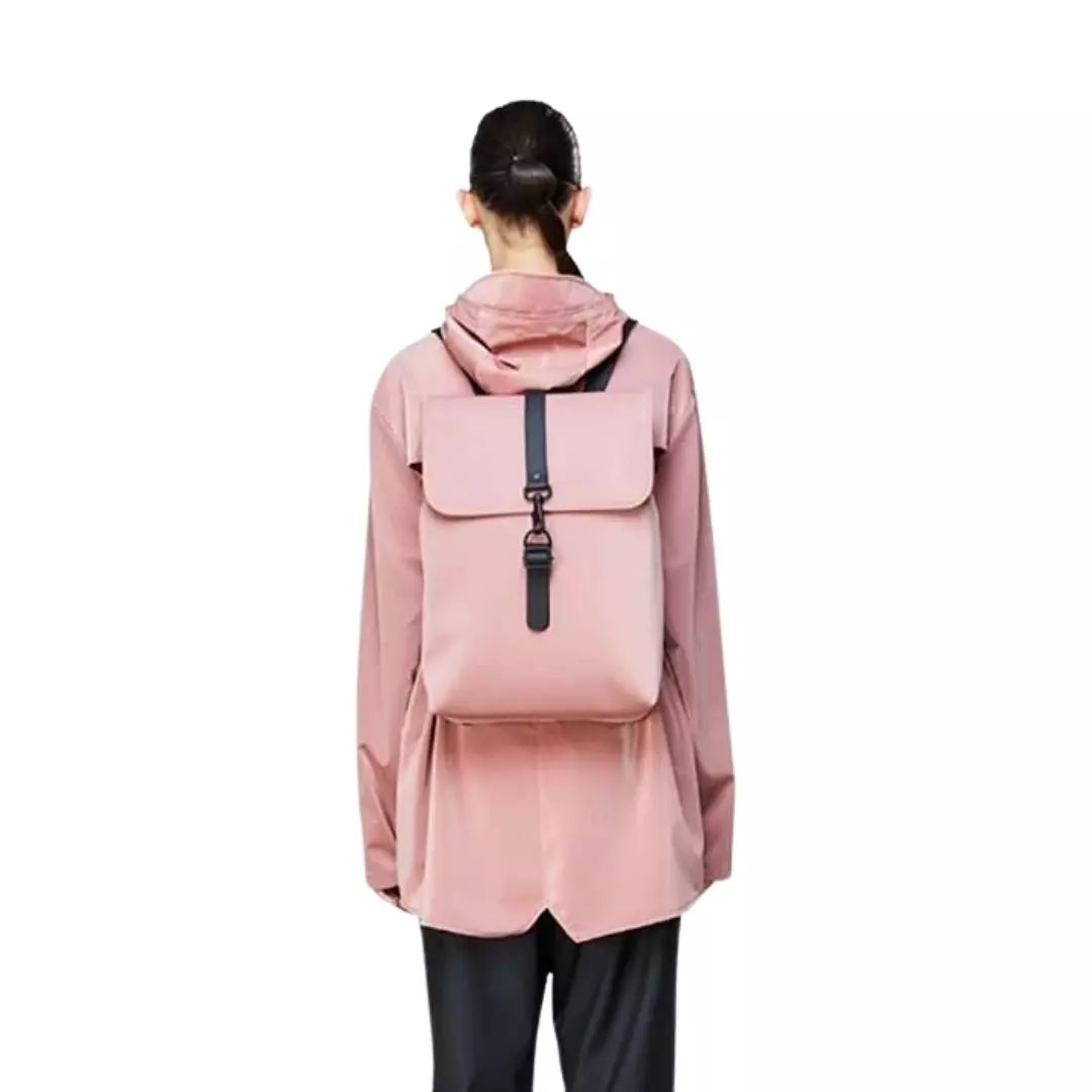 Rains waterproof backpack rucksack coral pink worn on the back of a woman